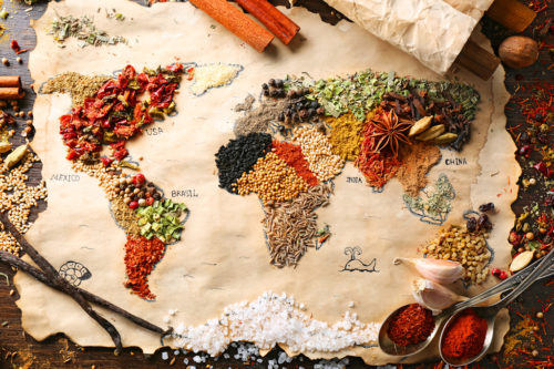 Map of world made from different kinds of spices on wooden background